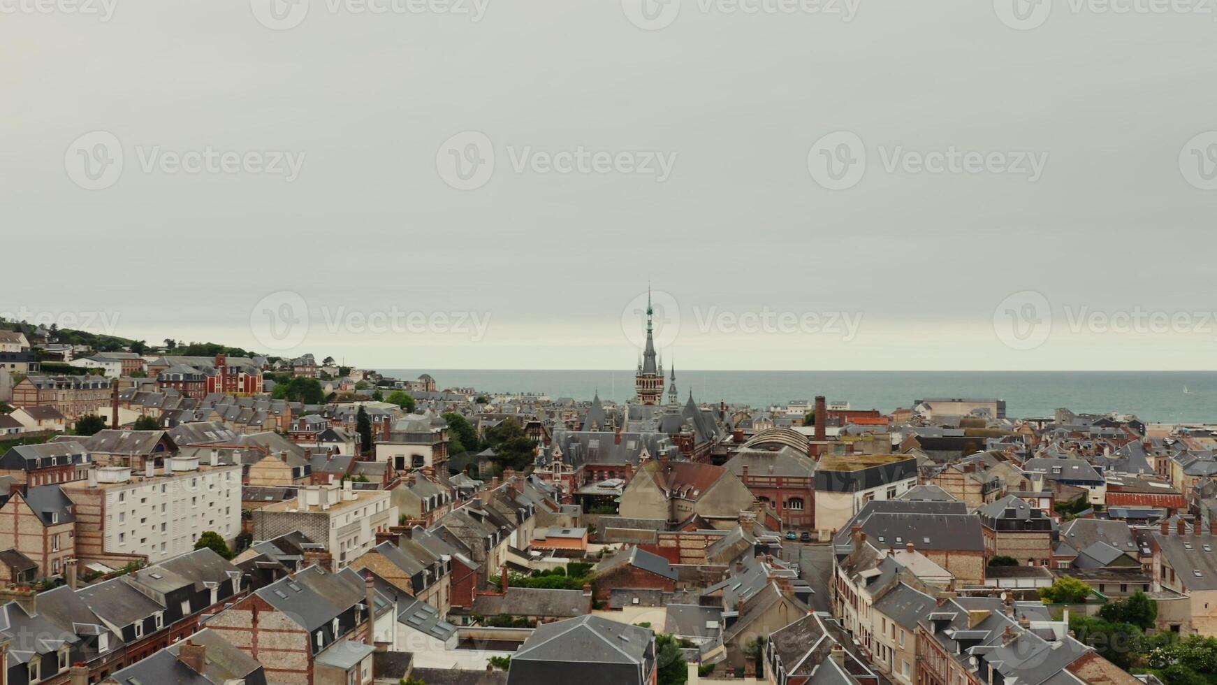 Horizontal panning from a drone, a view of an old European city located on the banks of the English Channel. The tower of the Benedictine Palace rises above roofs of historic houses, F camp, France photo