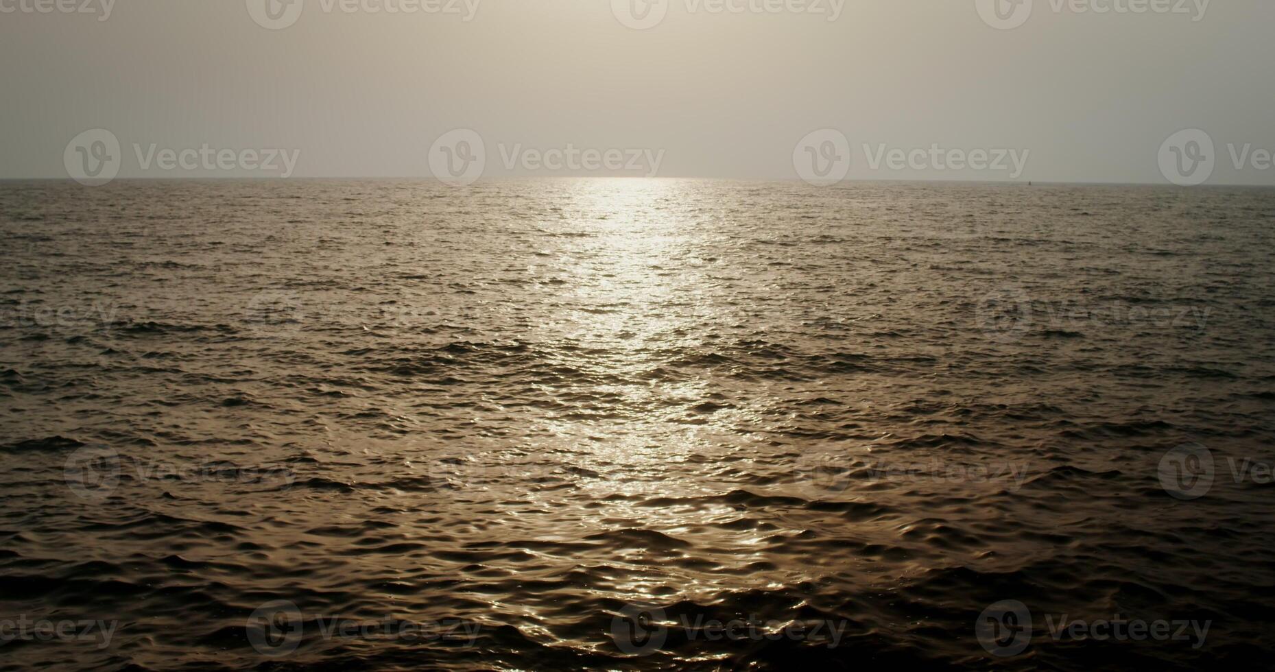 Sea or ocean water. The light of the setting sun is reflected in the sea ripples. Small waves, you can not see the shore. 4k , red komodo photo