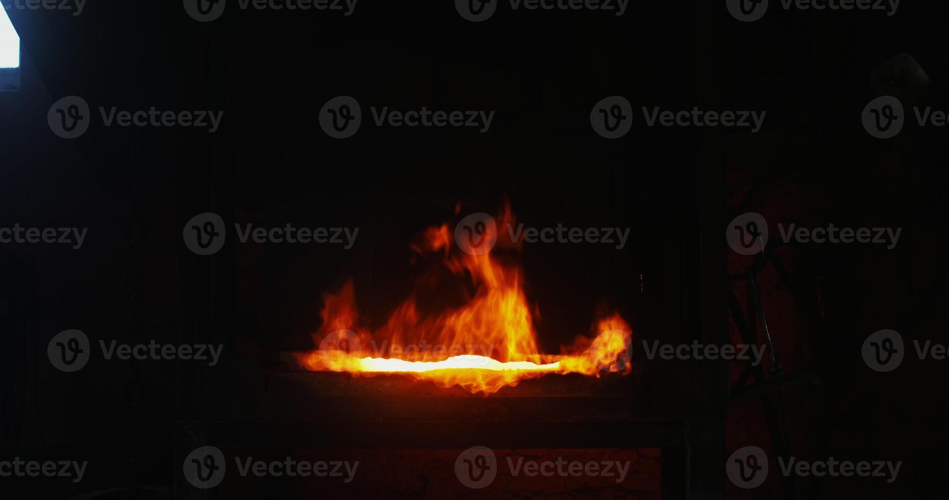 Kindled fire in the blacksmith's furnace, close-up. A strong flame breaks out of the furnace and rises up. There are no people in the . 4k , red komodo photo