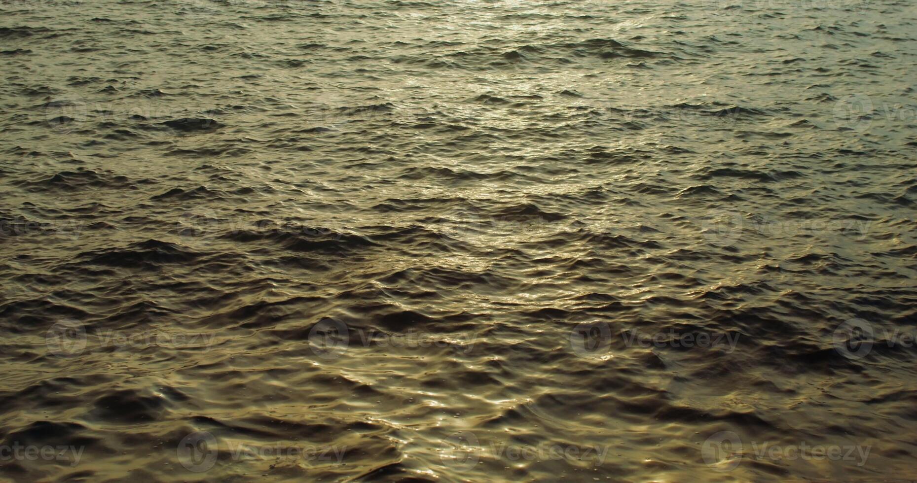 The dim light of the setting sun is reflected in the sea water. Light waves on the surface of the sea. The was filmed in the evening. 4k , red komodo photo