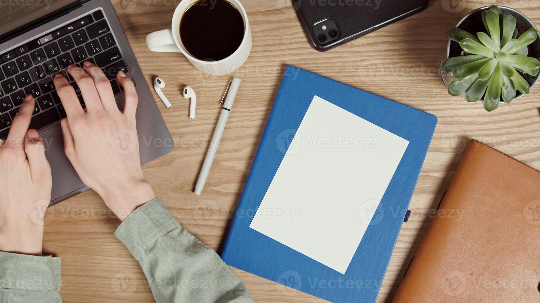 A white paper lies on a notepad on the desktop of a modern young woman typing on a laptop. Close-up of female hands, no face. Place to copy. in 4k, red komodo photo