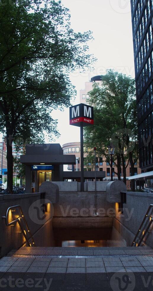 View of the entrance to the underground metro station, equipped with an elevator and located between residential buildings in Amsterdam, the Netherlands. 4k vertical , red komodo photo