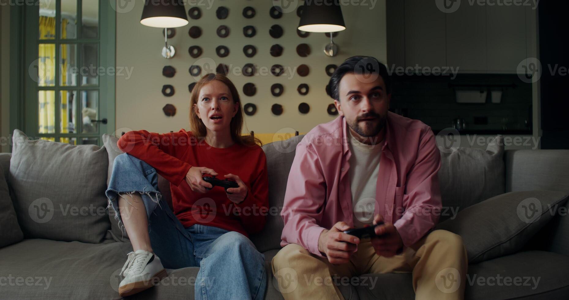 A man and woman sitting on a couch playing games photo
