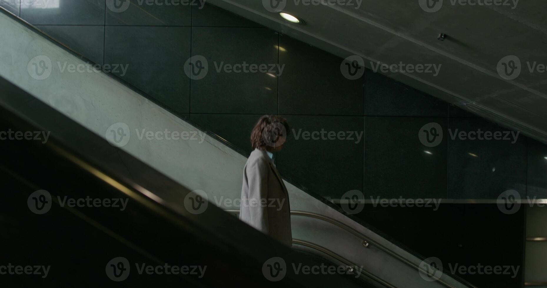 A woman in casual clothes walks down the stairs to the subway photo