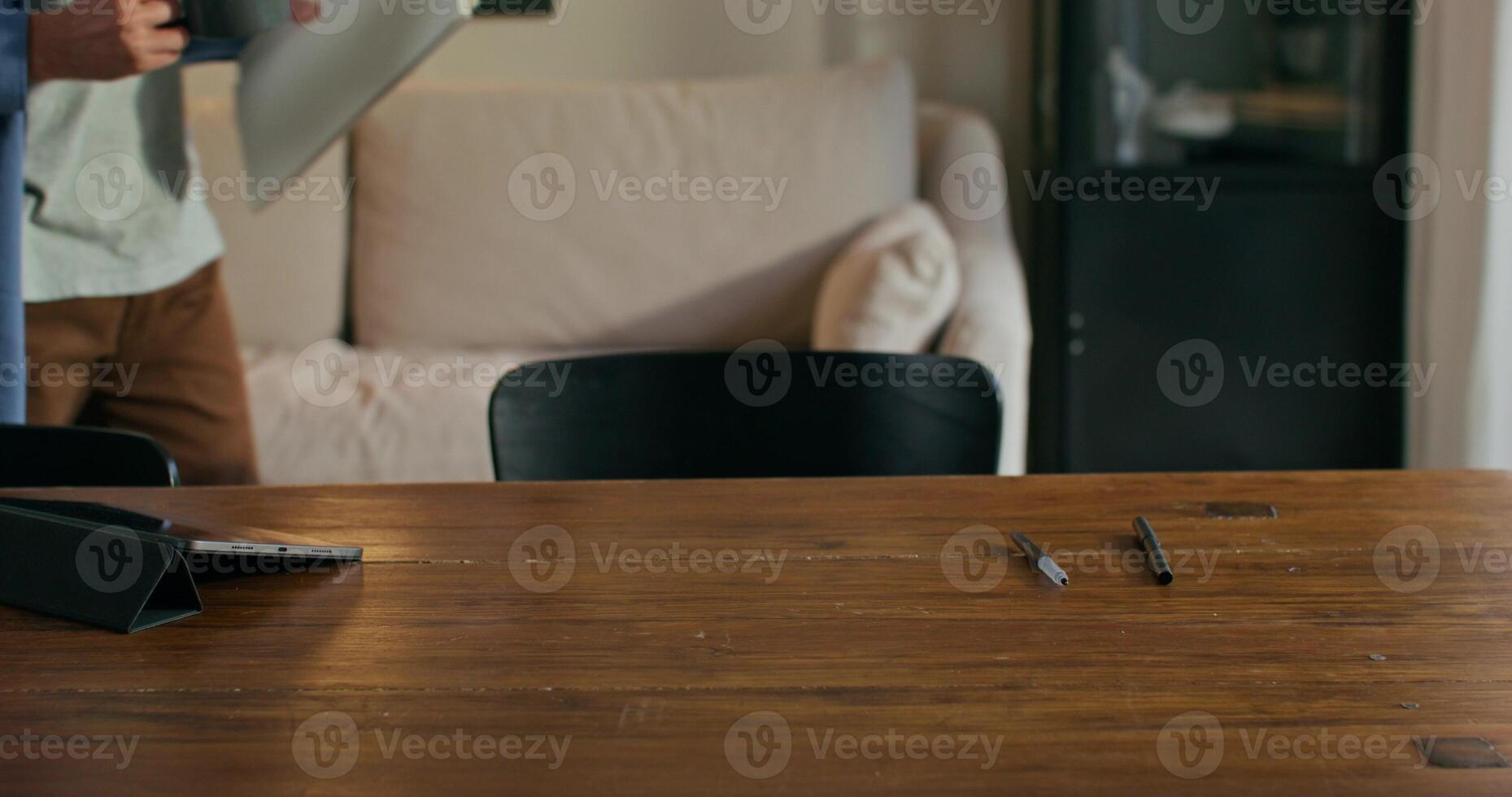 A man with glasses, with a cup in his hand, sits down at the table and starts writing in a notebook, working at home photo
