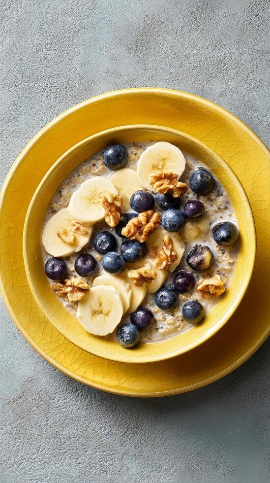Breakfast Bowl With Sliced Bananas, Blueberries, and Walnuts Served in a Yellow Bowl. photo