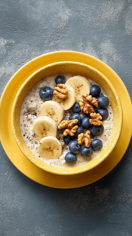 Breakfast Bowl With Sliced Bananas, Blueberries, and Walnuts Served in a Yellow Bowl photo