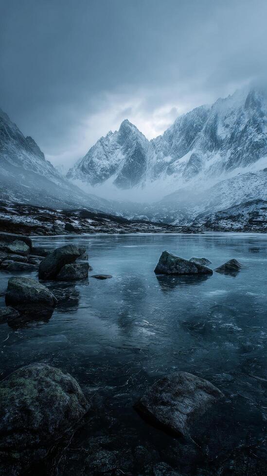Mountain Range Reflected in Still Water Under Cloudy Sky During Early Morning in a Remote Wilderness photo