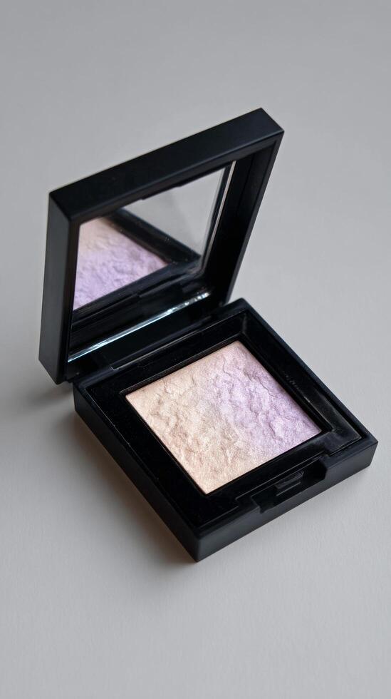Highlighter Compact With Mirror Reflecting Soft Pastel Hues on a Neutral Background photo