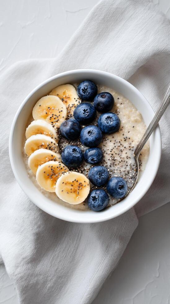 Healthy Bowl of Oatmeal Topped With Fresh Blueberries and Banana Slices for Breakfast photo
