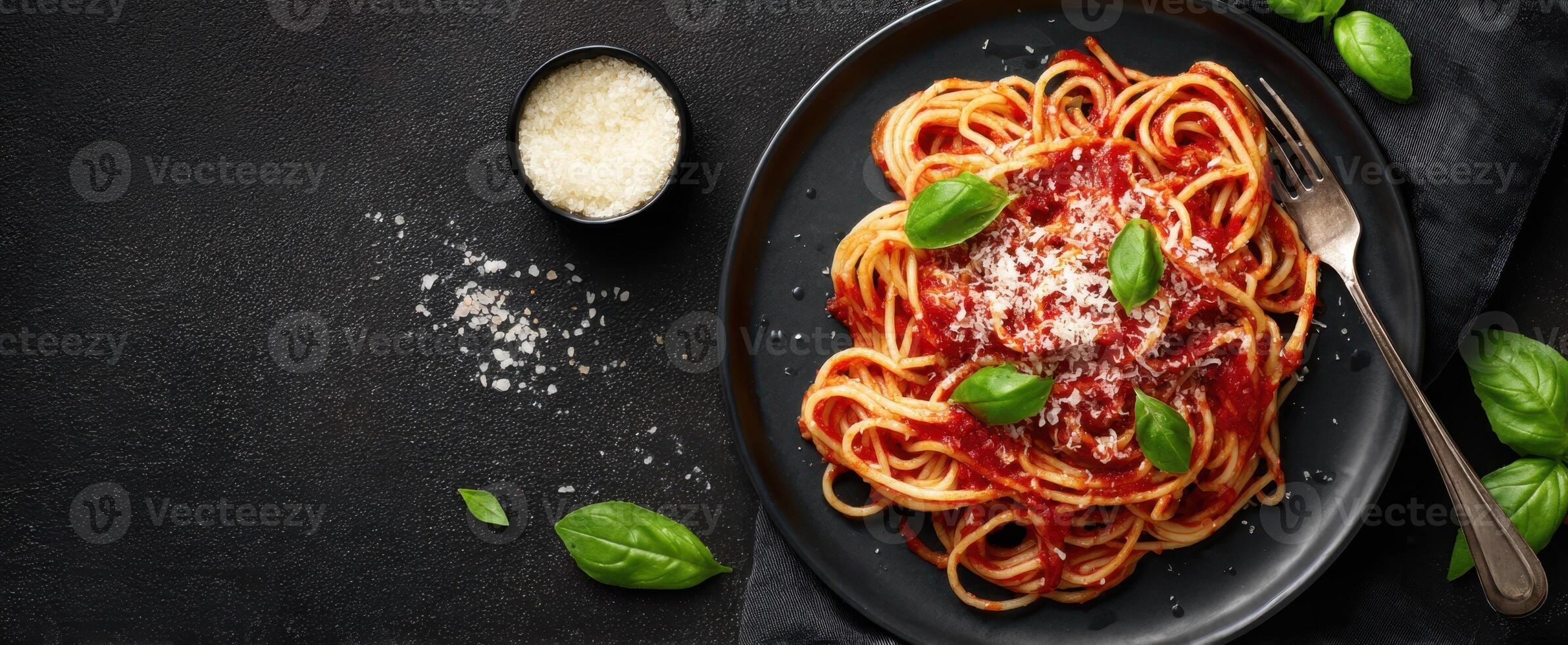 The delicious spaghetti pasta served with fresh basil and grated cheese photo