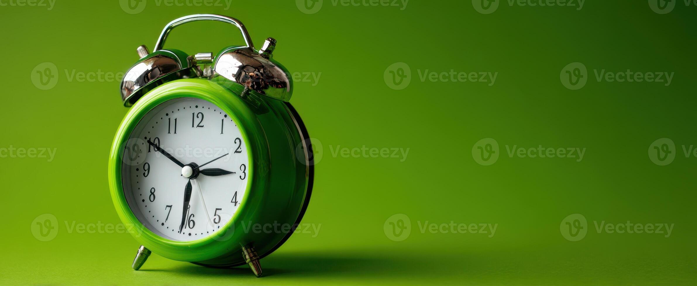 The vibrant green alarm clock with metallic accents on a solid backdrop. photo