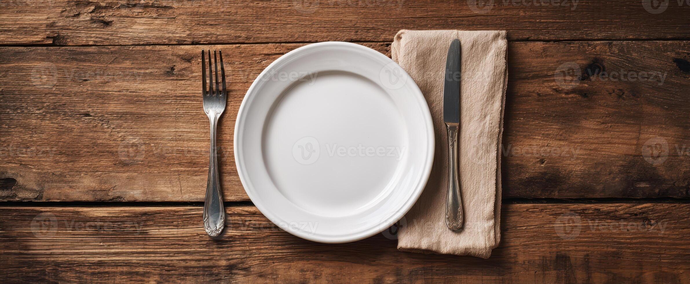 The elegant empty plate set on a rustic wooden table with cutlery. photo
