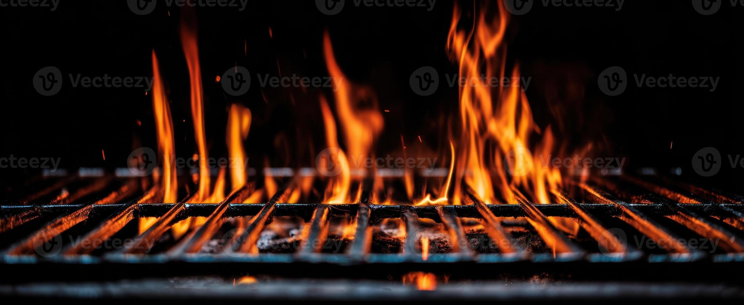 The flickering flames dance above a metal grill during a summer barbecue. photo