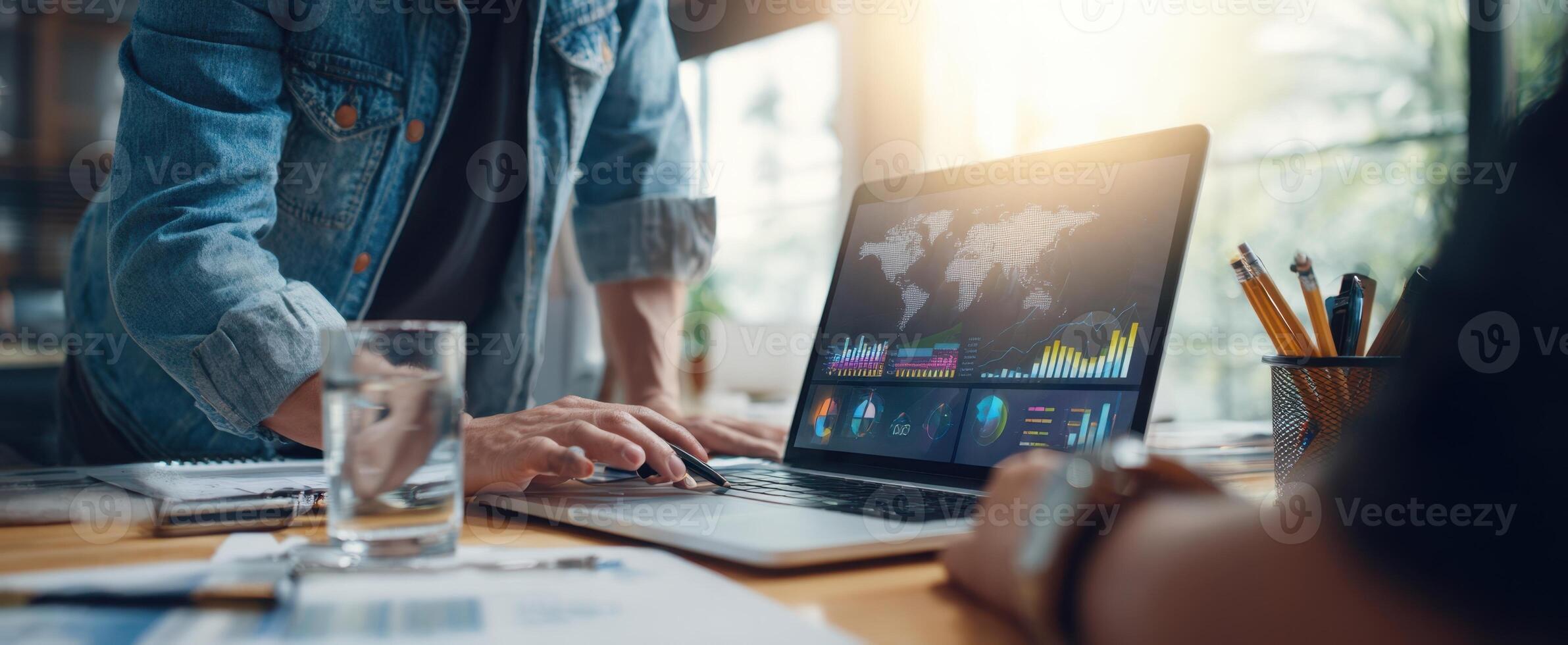 The laptop displaying data analytics during a collaborative business meeting. photo
