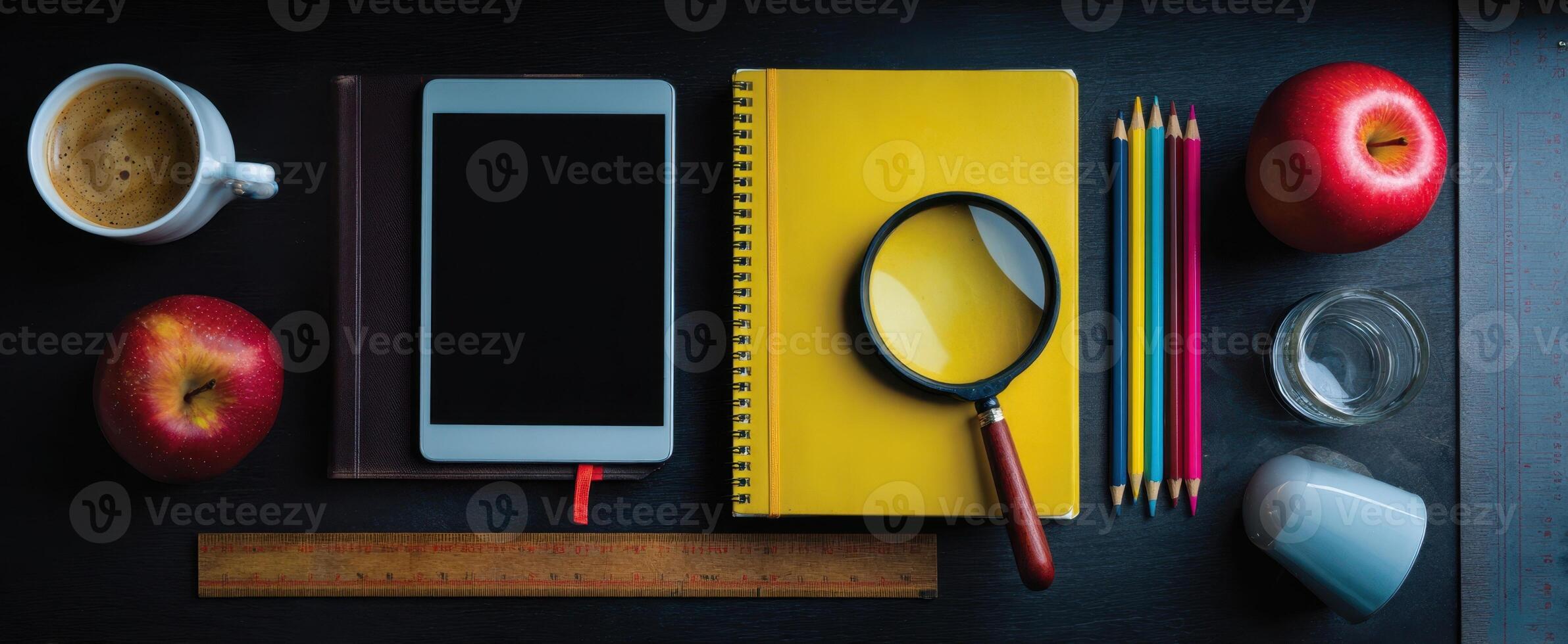 The creative workspace featuring a tablet, notebooks, and vibrant stationery items. photo