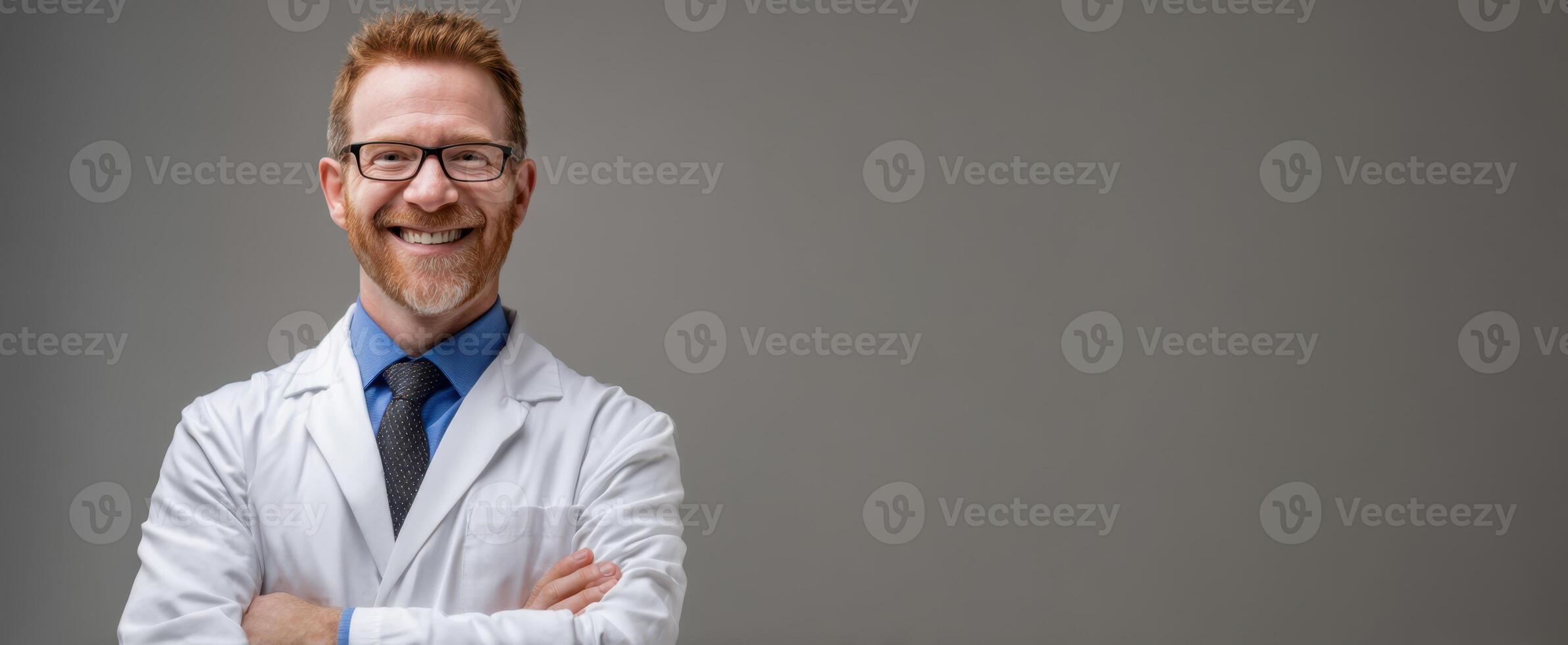 The smiling doctor with glasses in a lab coat against a gray background. photo