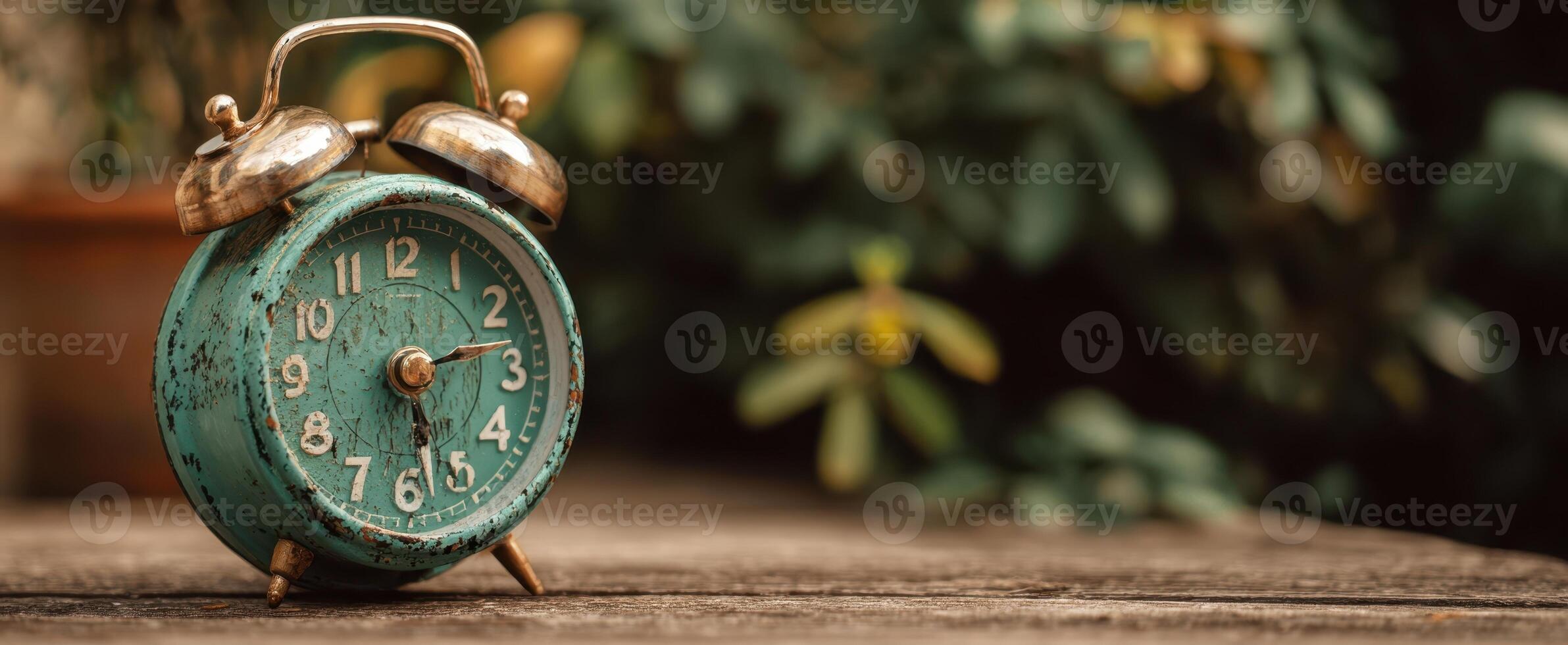 The vintage alarm clock resting on a rustic wooden surface in serene surroundings. photo