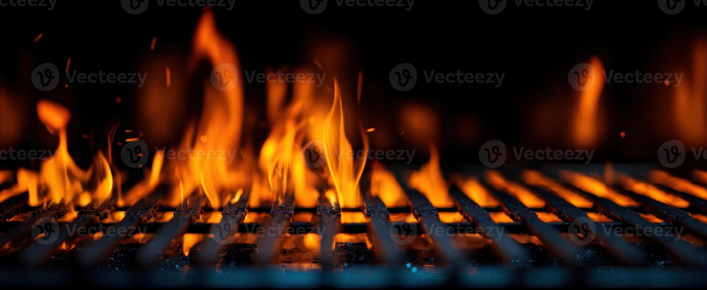 The mesmerizing flames dancing on a barbecue grill in the dark. photo