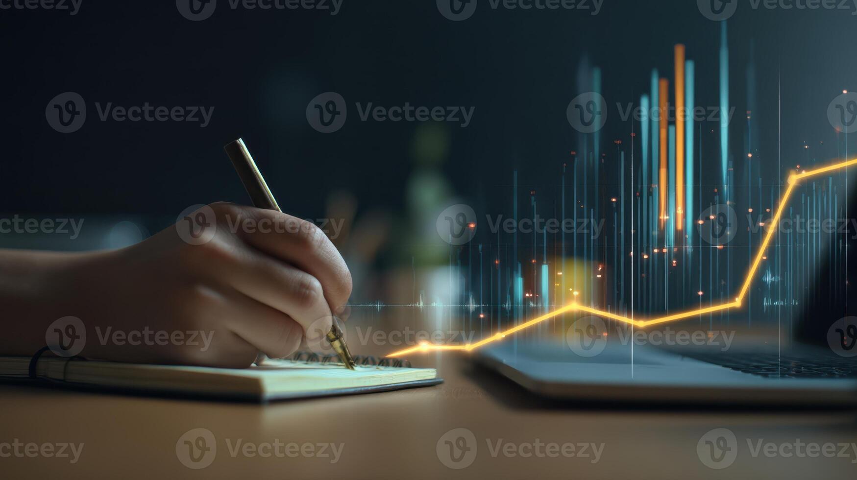 The hand writing notes with financial growth graph on the laptop screen. photo