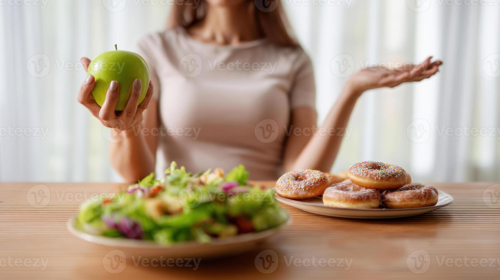 The woman choosing between a healthy apple and tempting donuts on a table. photo