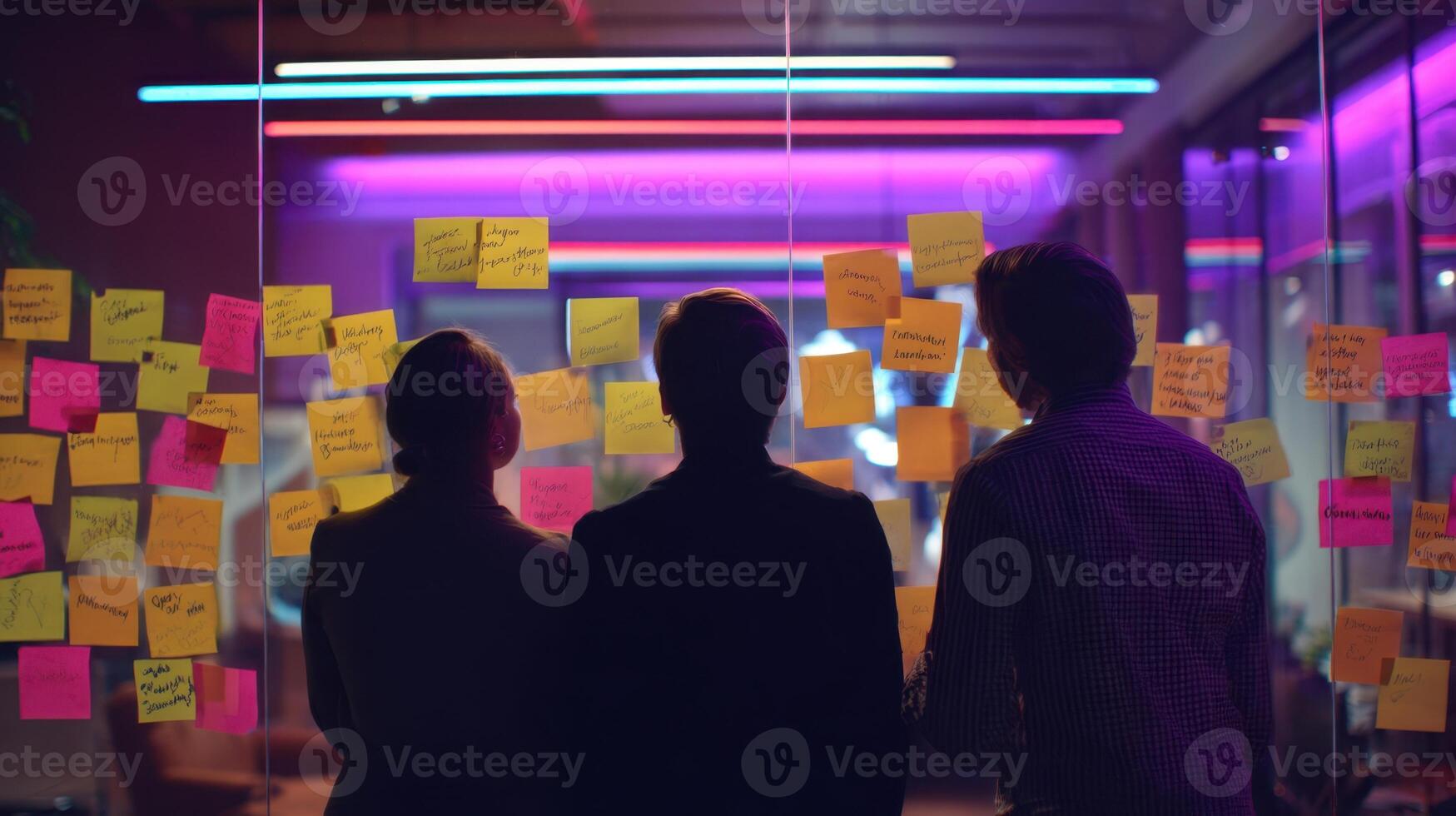 The professionals collaborating in a vibrant workspace filled with sticky notes. photo