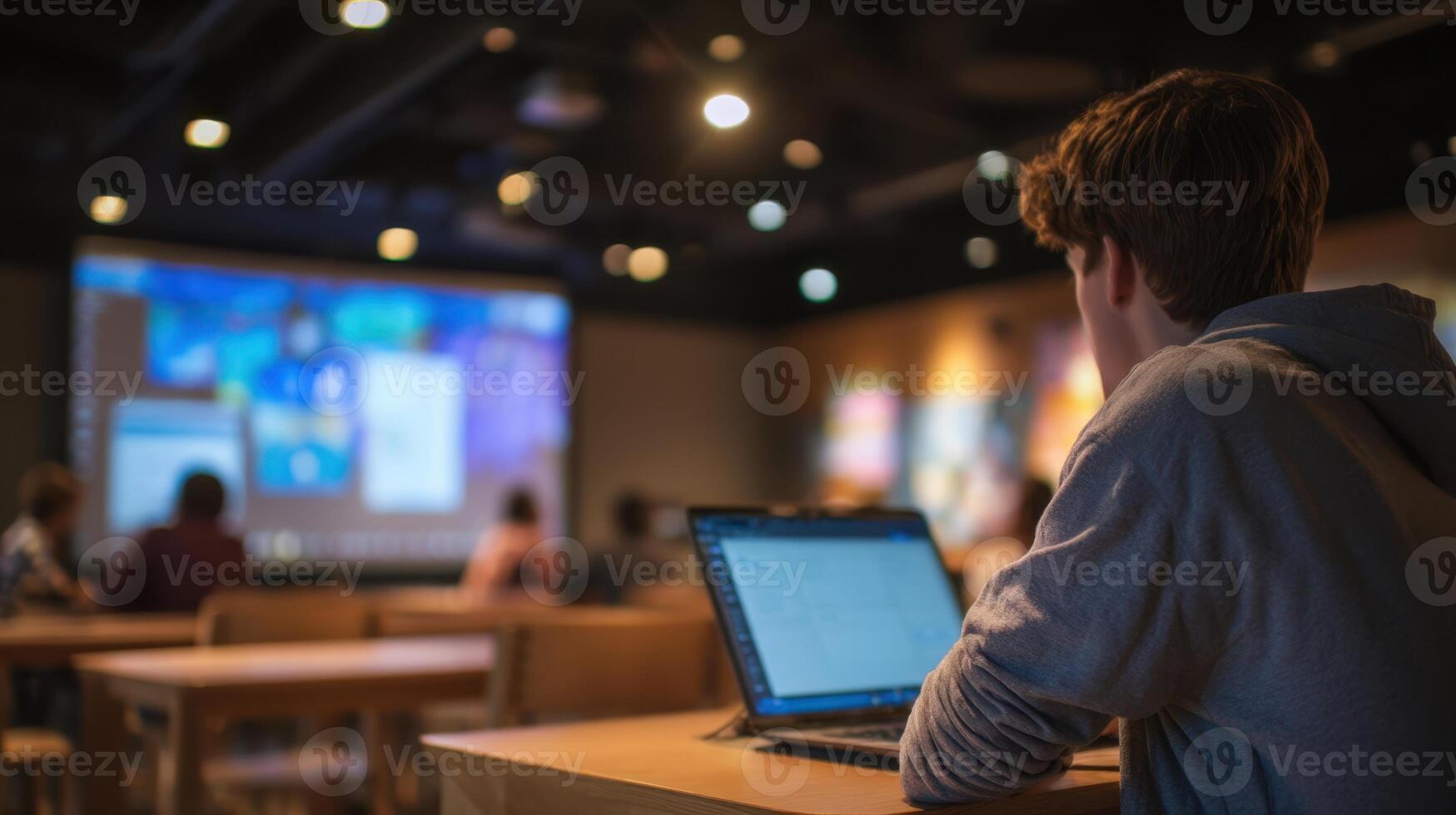 The student engaged in a collaborative learning environment using a laptop. photo