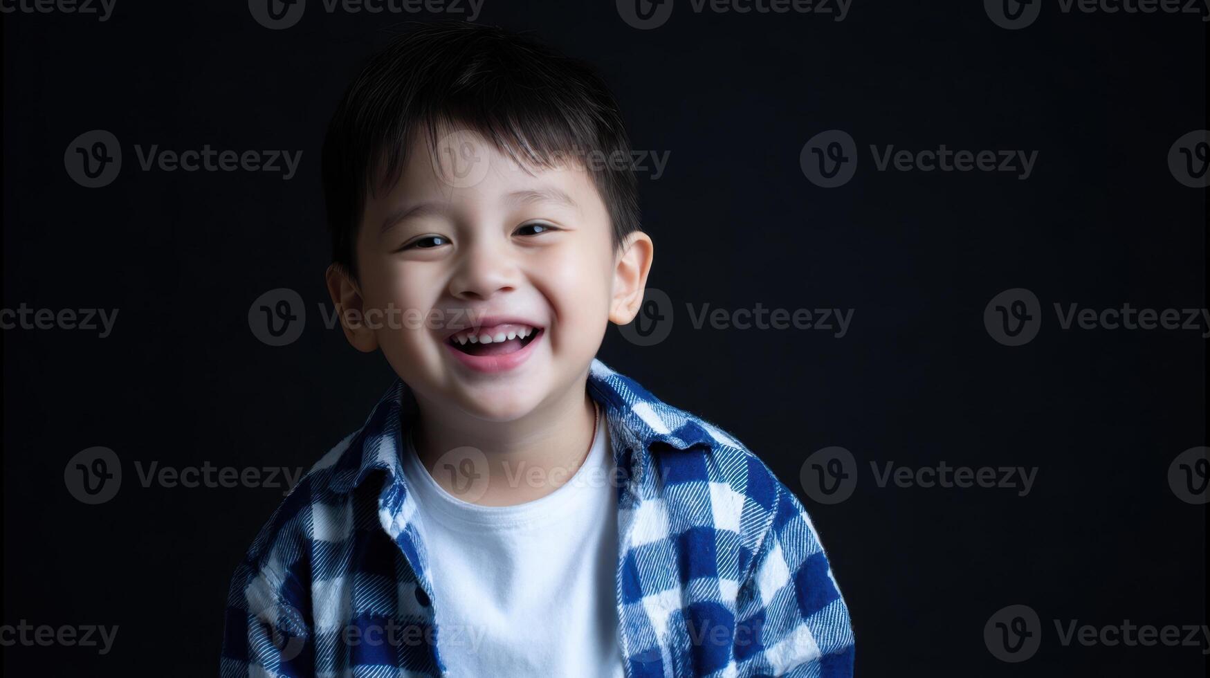 The joyful boy smiling brightly in a casual blue checkered shirt. photo