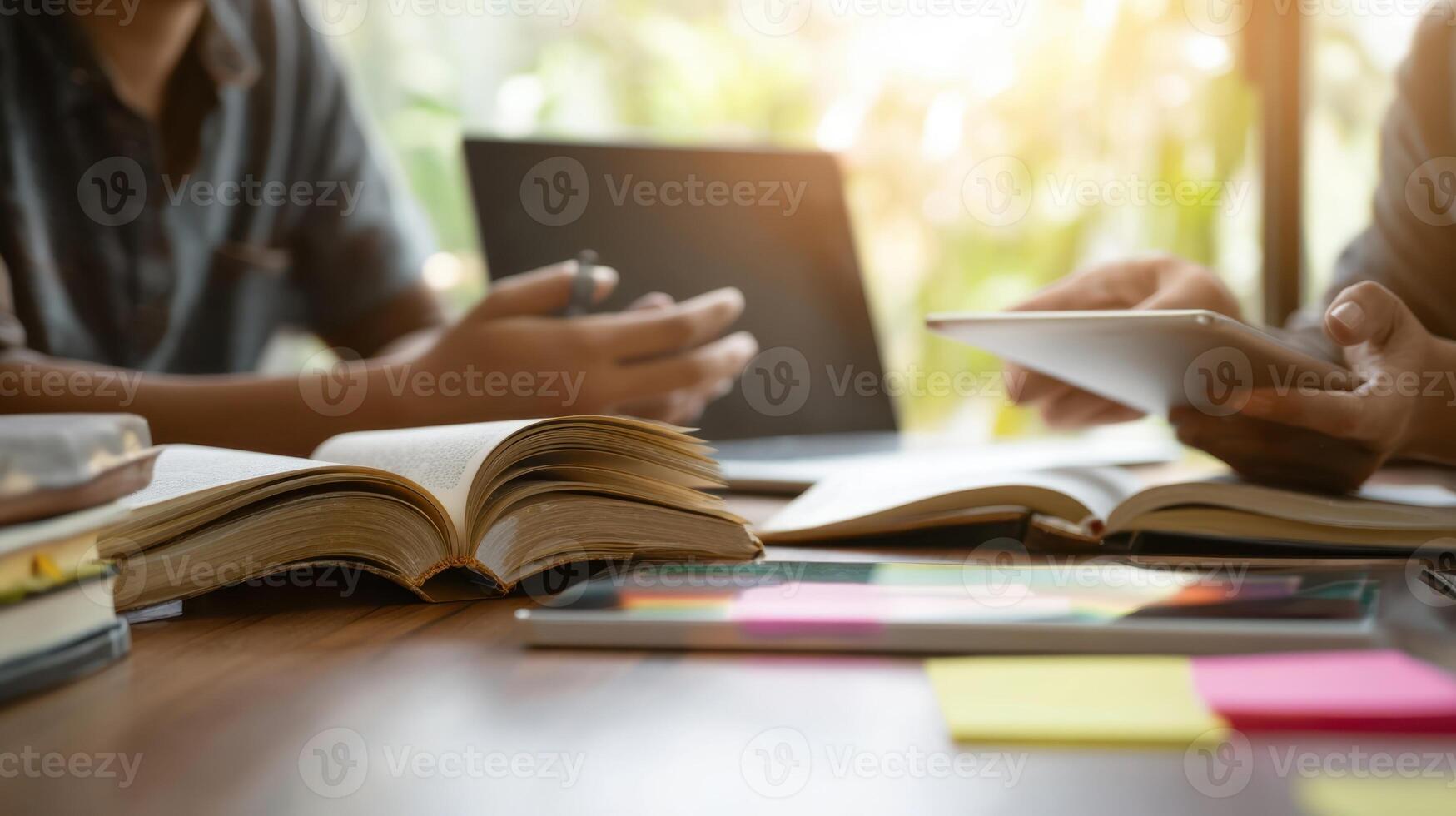The collaborative learning environment with books, tablets, and a laptop. photo