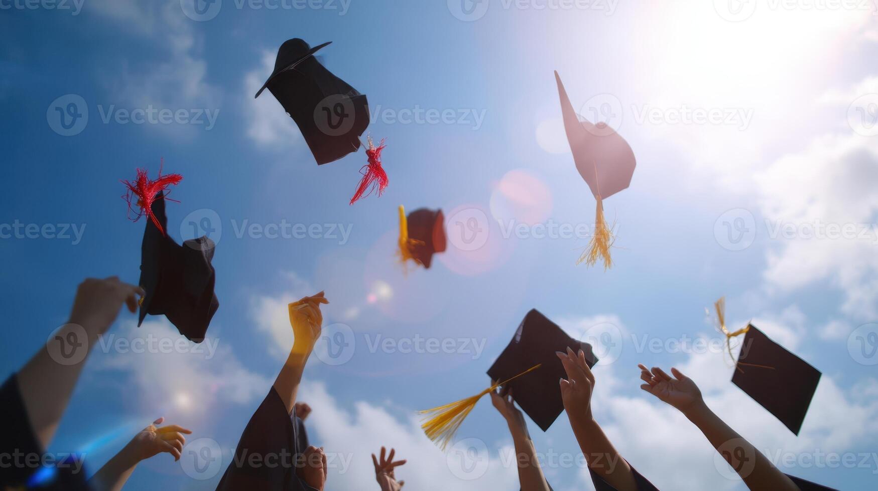 The joyful moment of graduates tossing their caps in celebration under a blue sky. photo