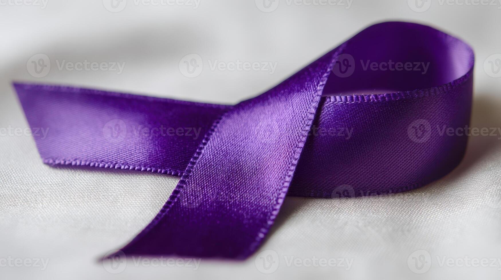 A purple ribbon laying on a white surface photo