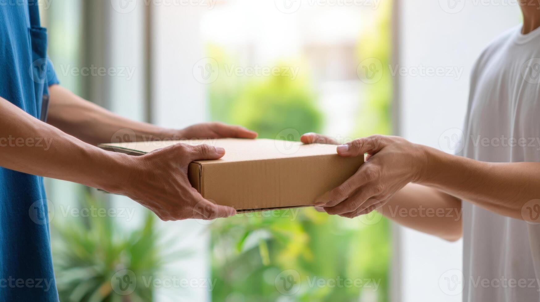 The hands exchanging a delivery package in a bright, modern living space. photo