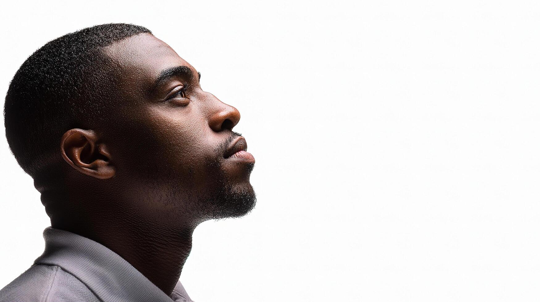 A man in profile looking up at something photo