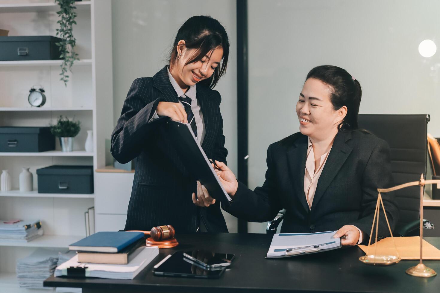 Two business women in suits are working together photo