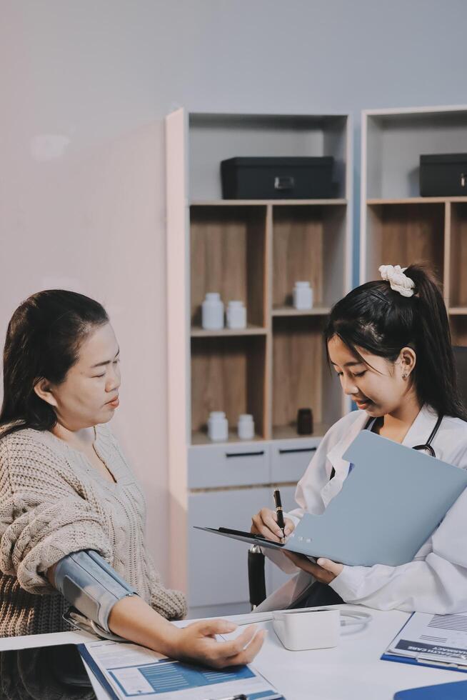 Asian woman doctor and patient in office photo