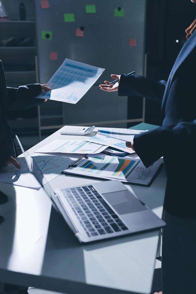 Two business people at a table with papers and laptops photo