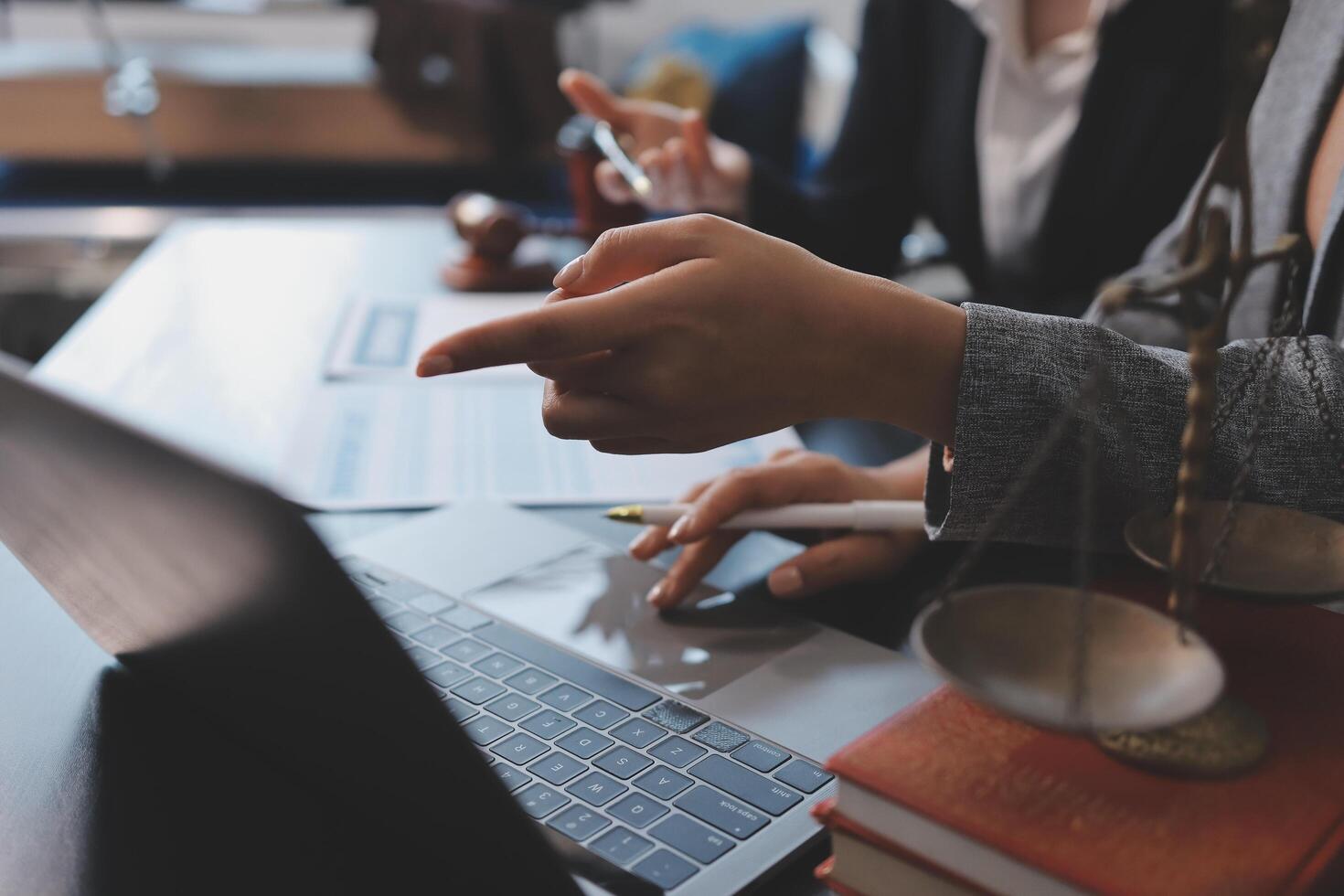 A woman is using a laptop computer while sitting at a desk photo