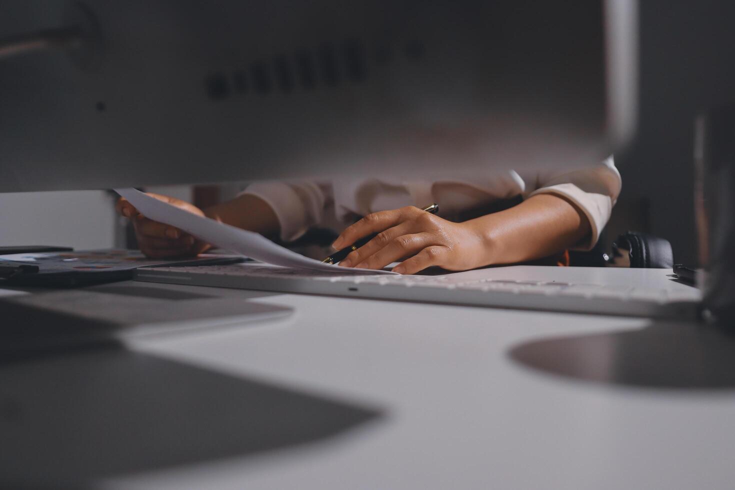 A person is typing on a keyboard at a desk photo