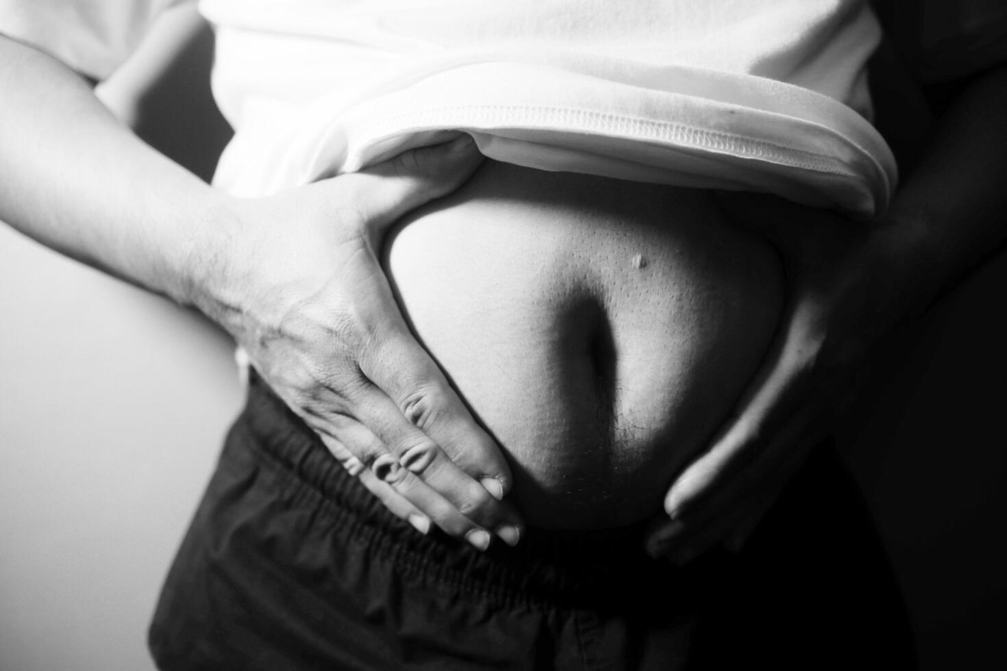 A black and white photo of a man holding his stomach