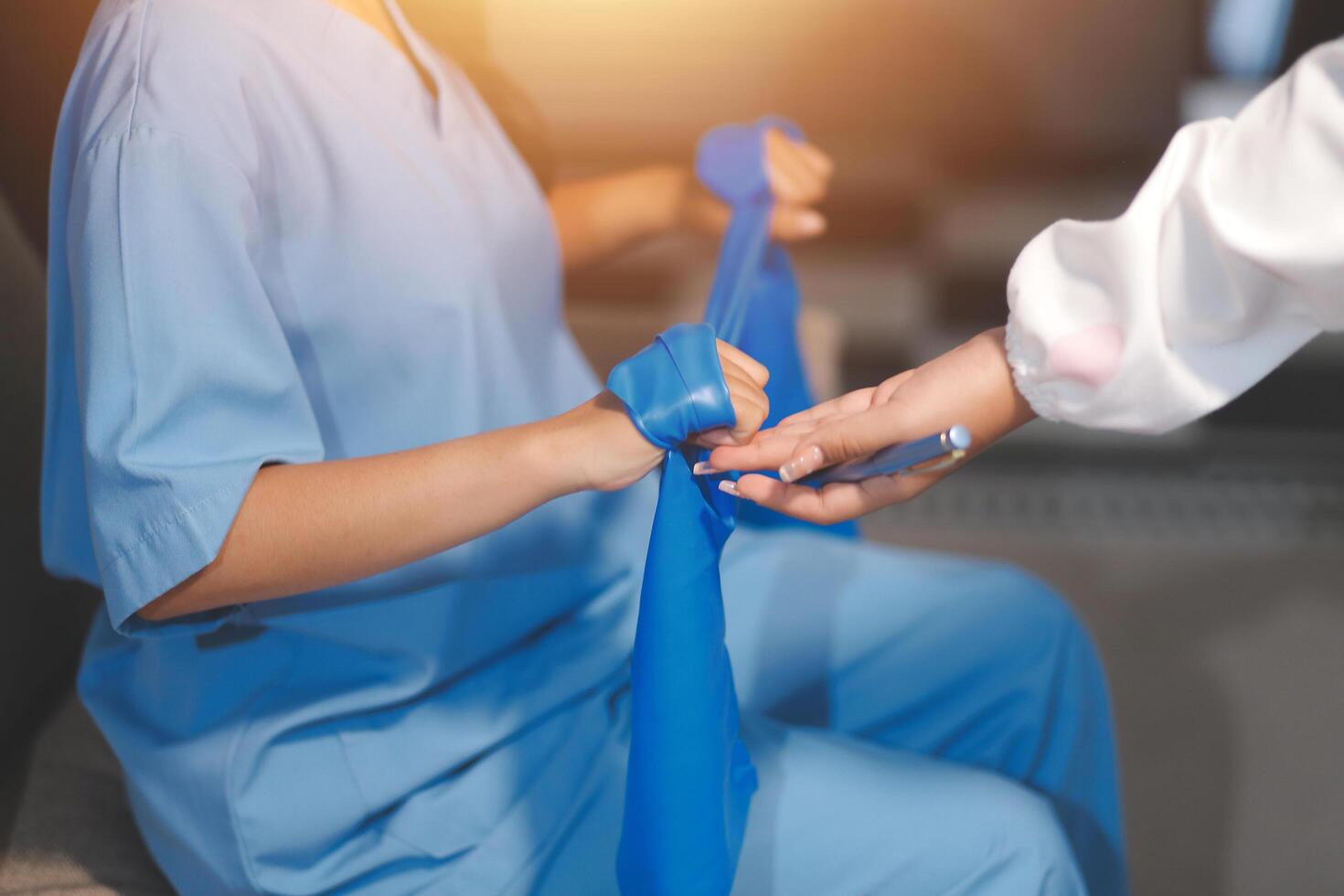 A doctor is holding a blue bandage to a woman's arm photo