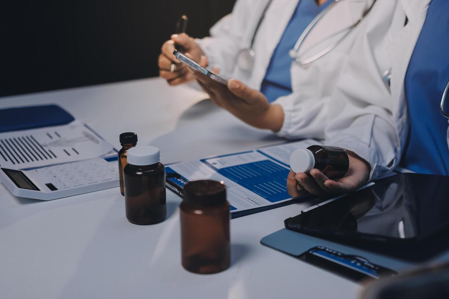 Two doctors are working on a tablet and a clipboard photo