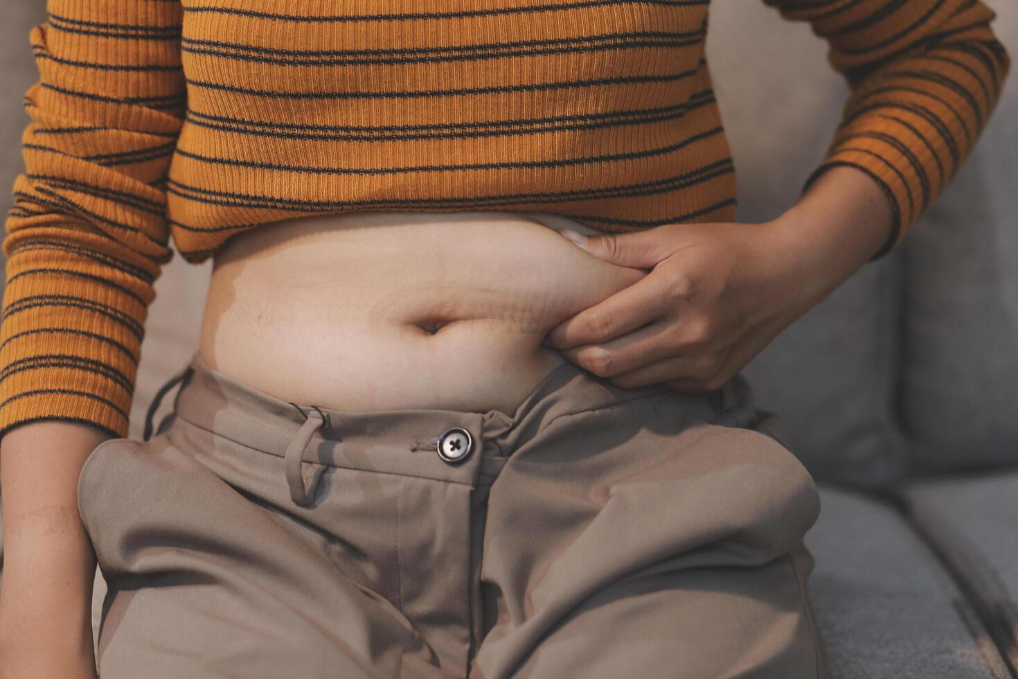 A woman with a large belly sitting on a couch photo