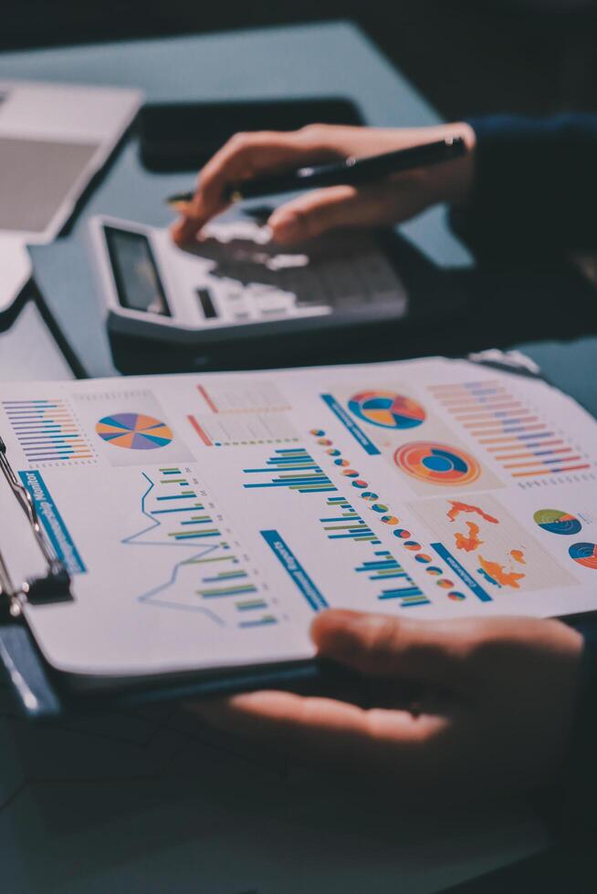A business person is using a calculator to calculate the financial data photo