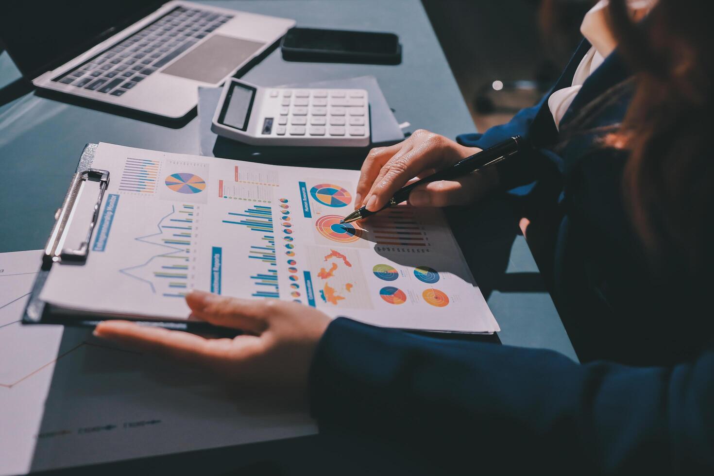 A person is working on a document with graphs and charts photo