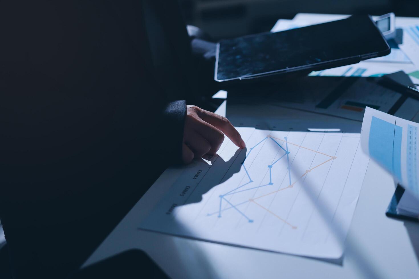 A person in a suit is looking at a graph on a tablet photo
