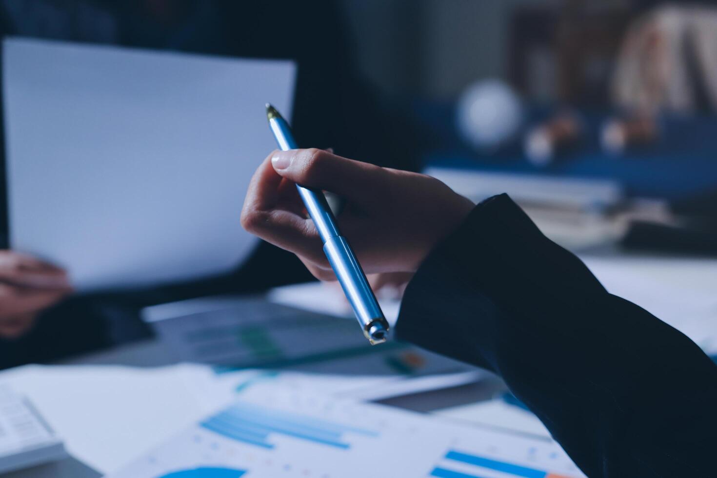 A person holding a pen and paper while sitting at a table photo