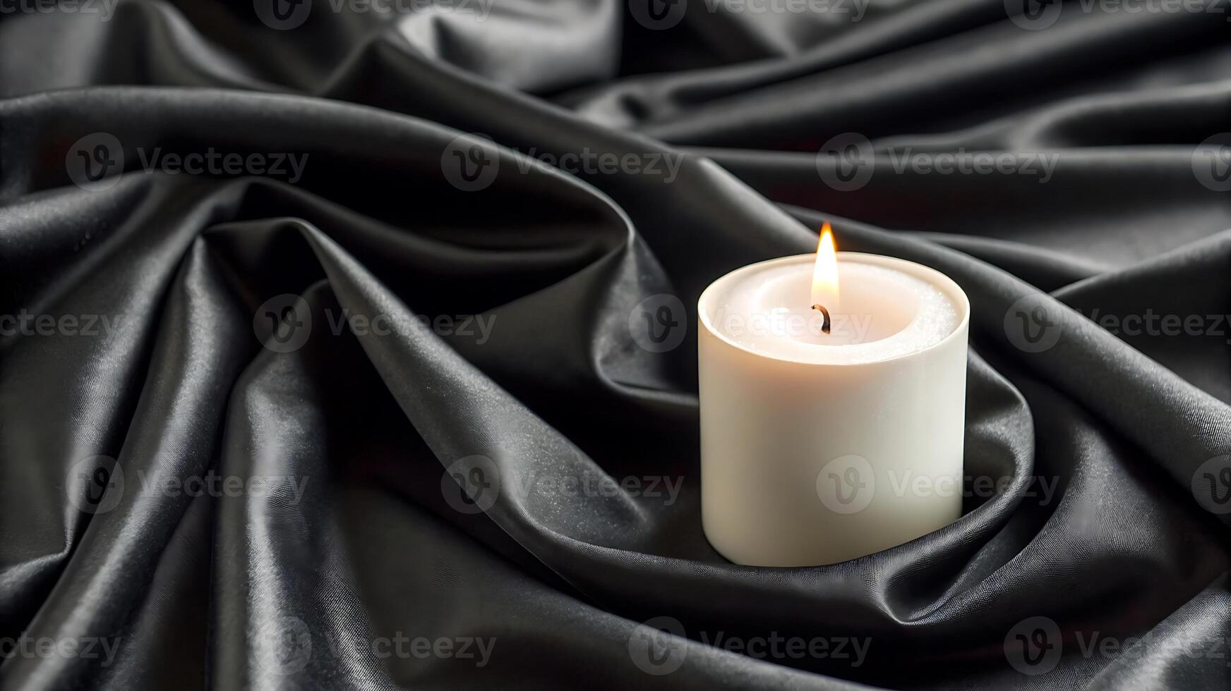 a single candle is sitting on a black cloth photo