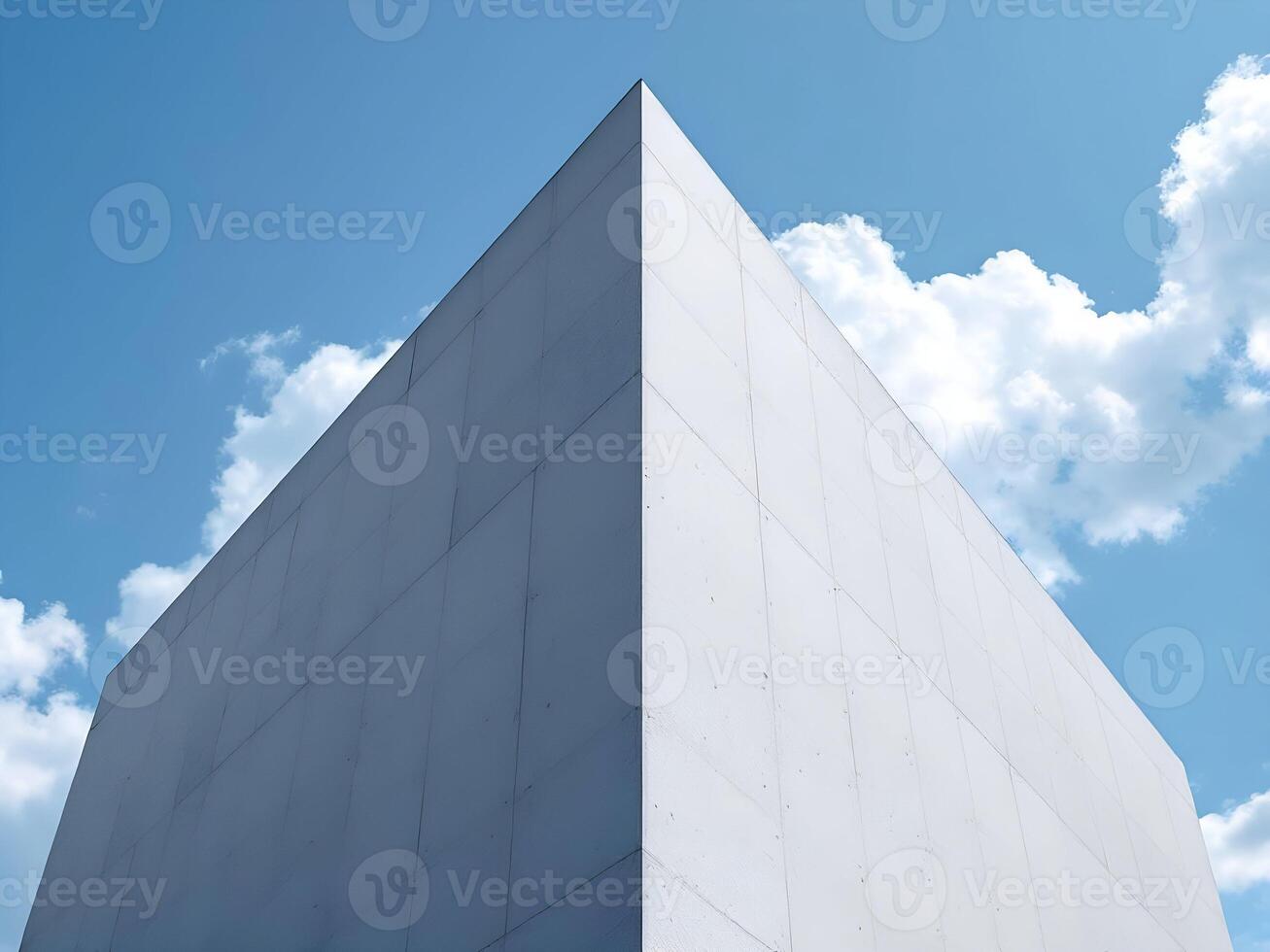 Architectural detail of a modern white building, highlighting sharp angles and deep shadows under a bright sky photo