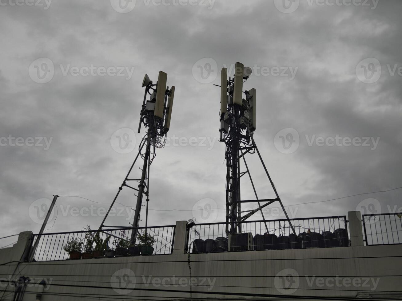 Telecommunication Towers on Building Rooftop Under Cloudy Sky photo