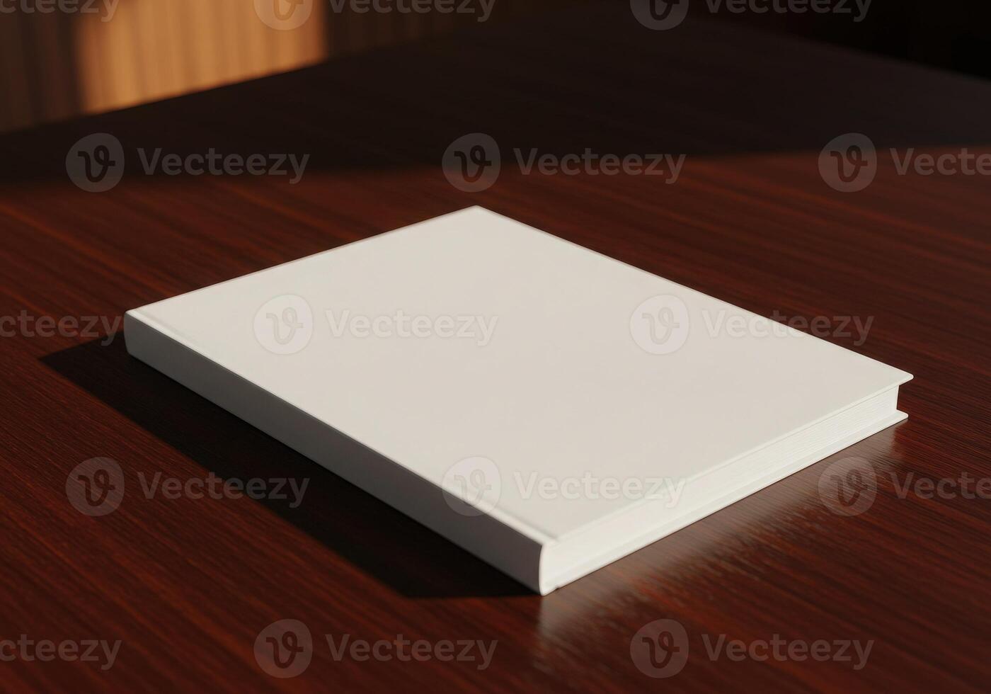 A white book sitting on a table in front of a window photo